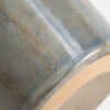 Primer plano del esmalte azul grisáceo y la base sin esmaltar de un mate de cerámica