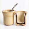 Mate de cerámica beige con bombilla junto a una pieza en sección que muestra su interior