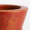 Detalle del borde redondeado y el esmalte rojizo de un mate de cerámica terracota