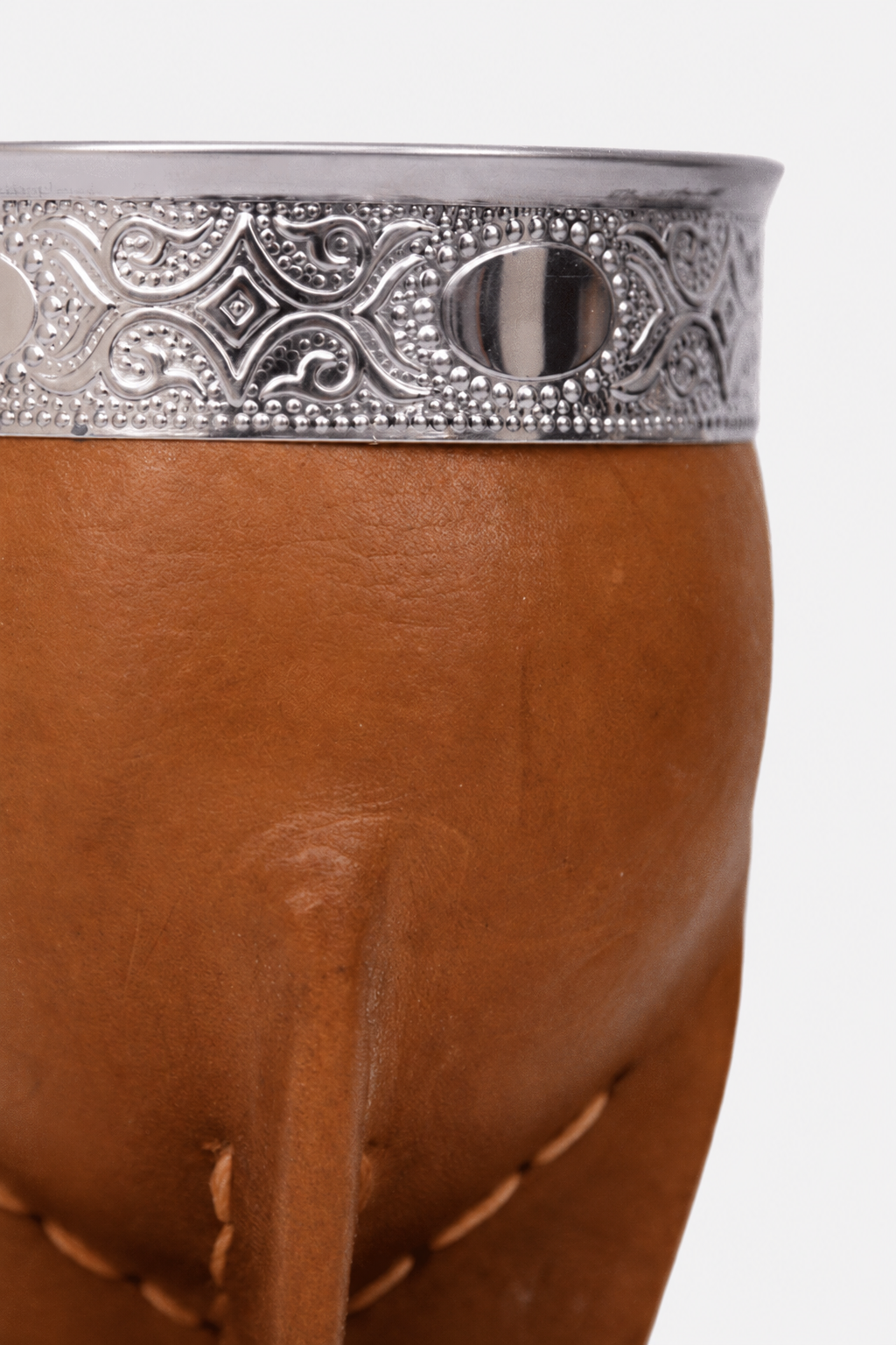 Detalle de la virola de acero cincelada y el cuero mostaza del mate imperial de calabaza